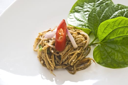 Spicy bamboo salad topped with a sliced red pepper. Traditional Thao Cuisine.