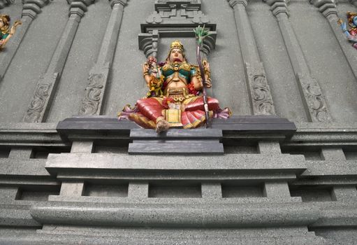 A colorful stone wall statue of the Hindu deity Lakshmi