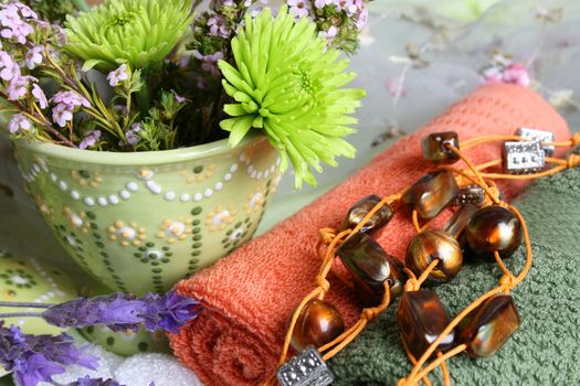 Spa Accessories setting with face cloths, jewelery and flowers