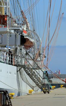 Side view of the historical yacht moored to the quay with ladder
