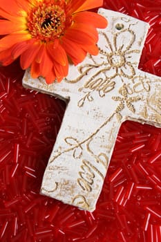 Wooden cross, engraved with word love, amongst beads
