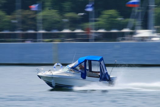 Motorboat riding fast on the bay with motion blurred background
