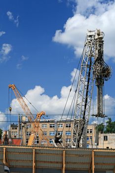 Cranes and a pneumatic air-hammer building new office center
