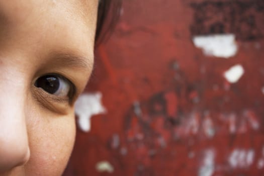 Close-up of an Asian girl's eye with a red background.