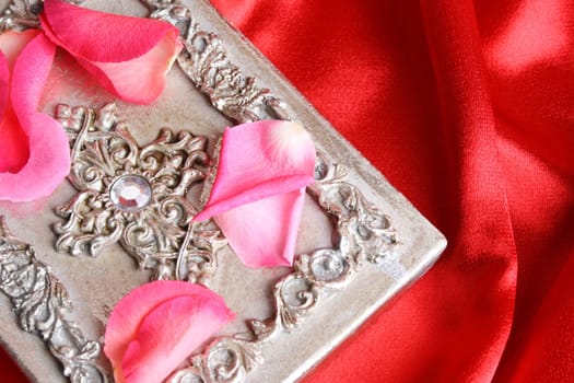 Pink rose petals on a silver ornate box