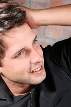 Male model against a rough brick wall background