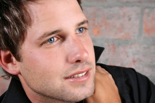 Male model against a rough brick wall background