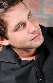 Male model against a rough brick wall background