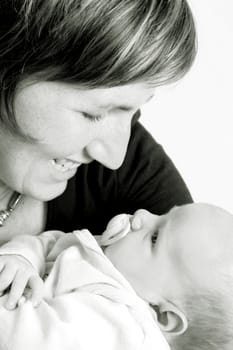 Smiling new mother holding her son in her arms