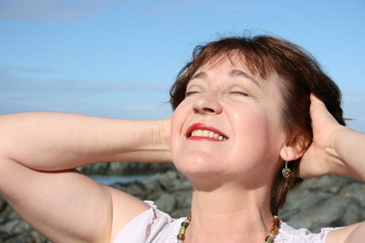 Beautiful mature brunette female on the beach