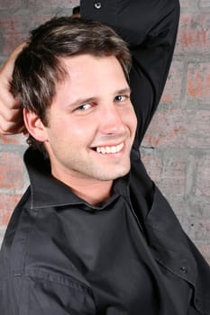 Male model against a rough brick wall background