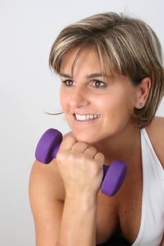Friendly mature female exercising with small weights
