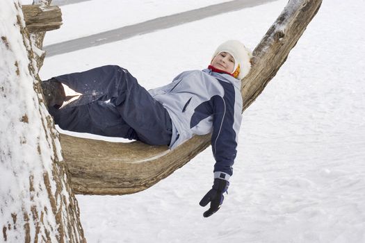Girl on tree. Winter time, Russia. Playng child. 