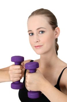 Young blonde exercising with light purple weights