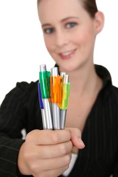 Young business woman.  FOCUS on the pens.