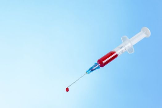 syringe with fresh blood. One drop on needle-point.