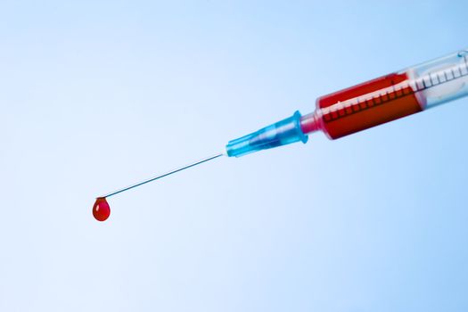 syringe with fresh blood. One drop on needle-point