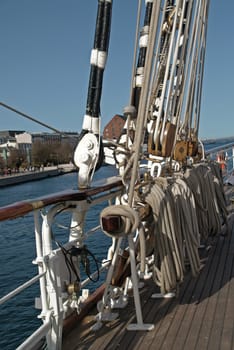 reeled sail ropes beside the ships railing
