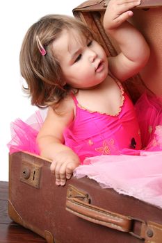 Little girl with short hair wearing a bright pink ballet outfit
