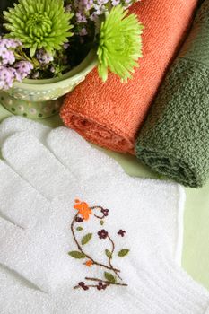 Spa Accessories setting with face cloths, scrub gloves and flowers