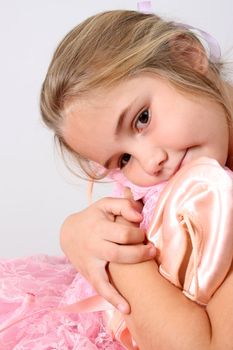 Young ballet girl holding her tutu and satin shoes
