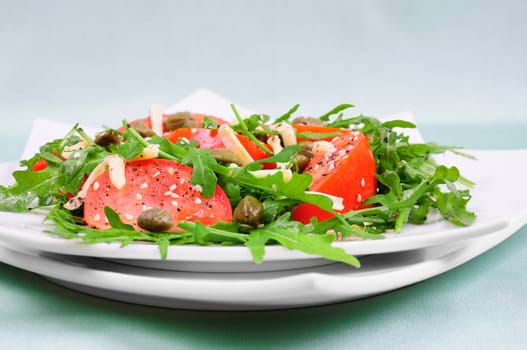 Tomato salad with arugula leaves with cheese and sesame seeds