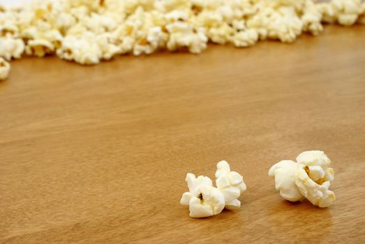 Two pieces of popcorn infront of many pieces.