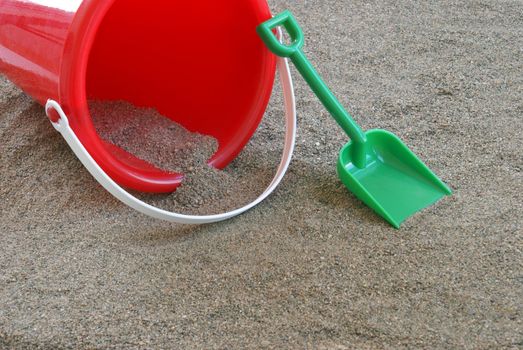 A shovel and bucket in the sand.