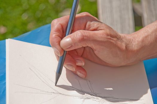 making sketches on a bench by a woman