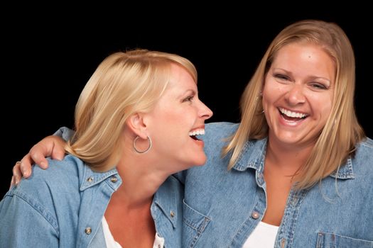 Two Beautiful Sisters Laughing Isolated on a Black Background.