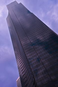 Angled skyscraper against a gray cloudy sky