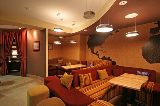 Interior of a modern coffee house with soft sofas and pillows