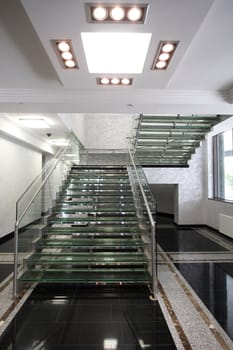 The big ladder from glass in a hall of office building