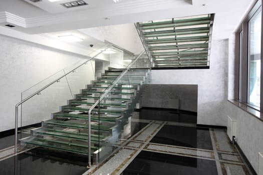 The big ladder from glass in a hall of office building