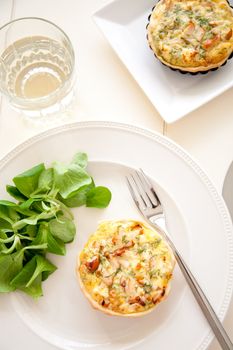 Delicious quiche with lamb's lettuce and a glass of white wine