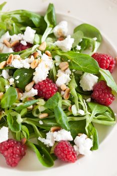 Delicious and healthy salad with lamb's lettuce, raspberries and goatcheese