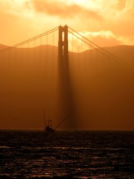 A sunset at the Golden Gate Bridge with Fisher-Boat in foreground