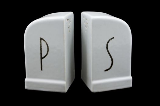 Deco White ceramic salt and pepper shakers isolated against a black backgroundv