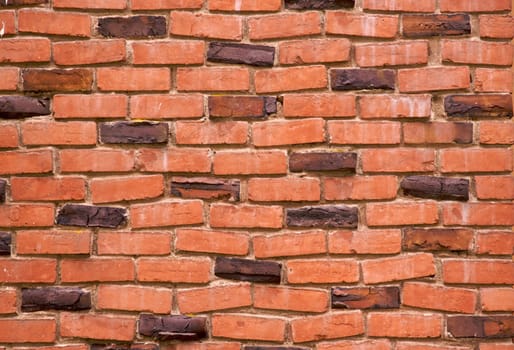 a red and dark brown brick wall on a 100 year old house with klinker bricks