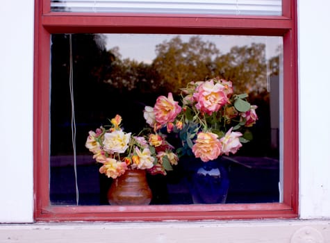 Two bouquets of flowers framed by a window