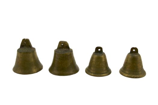 Four Small brass bells lined in a row against a white background