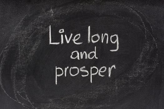 live long and prosper - abbreviated version of traditional Jewish religious blessing popularised by actor Leonard Nemoy as a Vulcan salute, white chalk handwriting on blackboard
