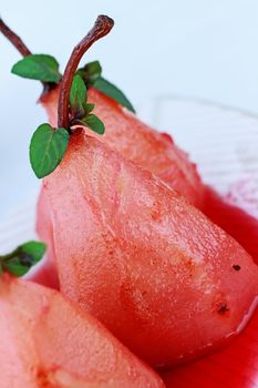 A group of three pears that have been poached in red wine sauce.

