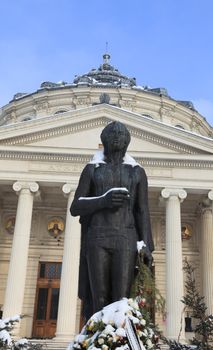 Image of the George Enescu's statue during the winter season in front of the Romanian Atheneum building in Bucharest,Romania.