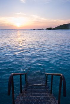 natural sea swimming pool with staircase and sunset
