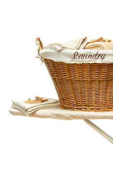 Laundry basket with towels on ironing board against white background
