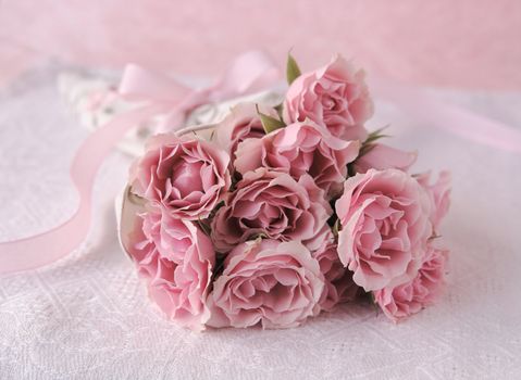 fresh bouquet of miniature roses with a pink ribbon