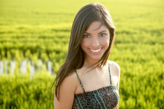 Beautiful brunette indian young woman in the green rice fields meadow