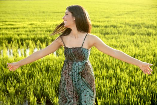 Beautiful brunette indian young woman in the green rice fields meadow