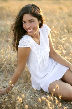 Beautiful indian brunette having a rest on a golden summer field